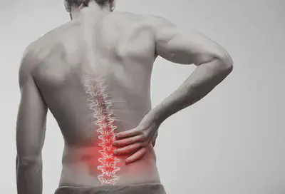 man touching lower back in pain