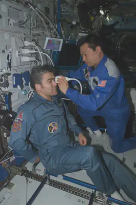 astronaut using handheld ultrasounds on another astronaut